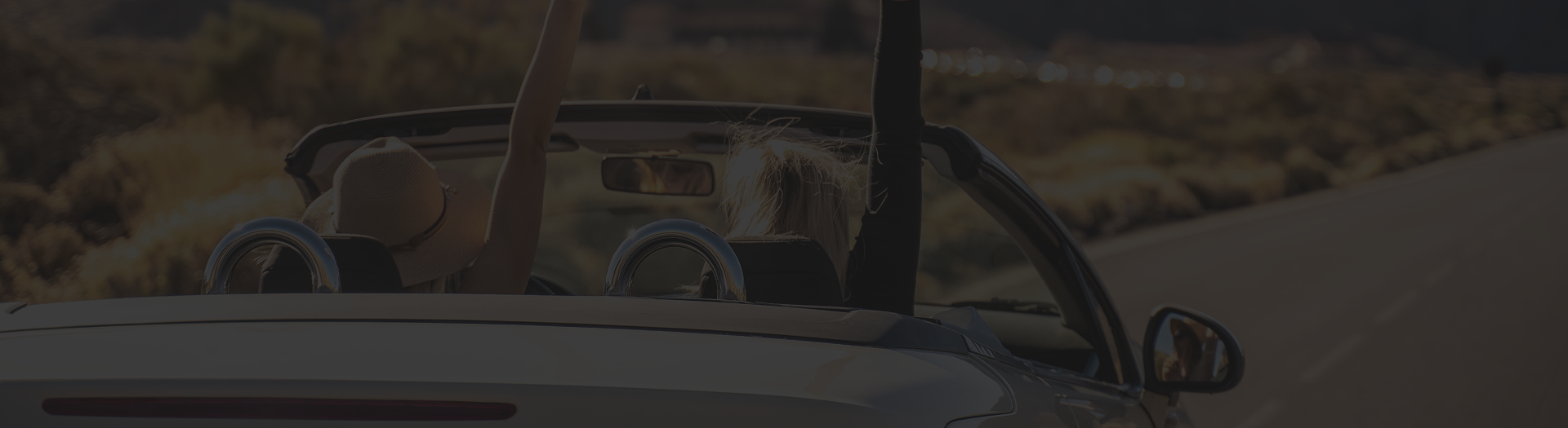 Woman with arm raised in convertible. | Golden Gear Automotive