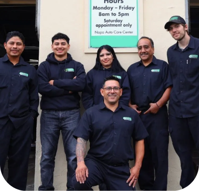 Group of six auto shop employees posing outside the business; all wearing matching uniforms. | Golden Gear Automotive