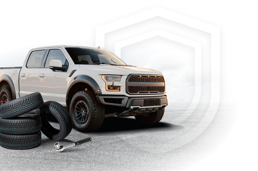 White pickup truck next to a stack of tires and a wrench. | Golden Gear Automotive