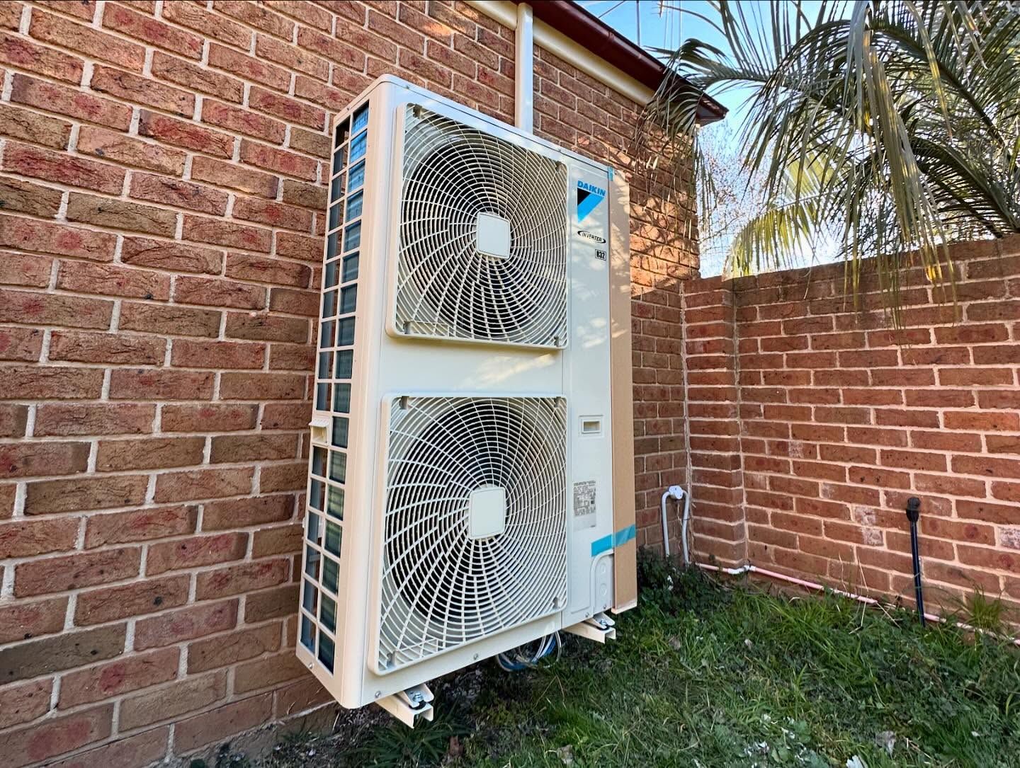 Air Conditioning Unit Attached to A Brick Wall Outside in A Yard — Canobolas Air in Dubbo, NSW