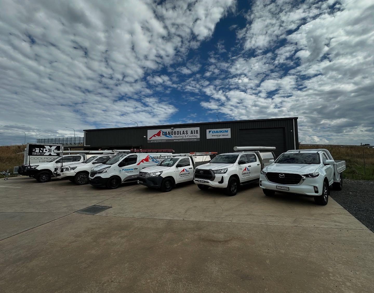 Fleet of White Work Trucks Parked in Front of A Building — Canobolas Air in Orange, NSW