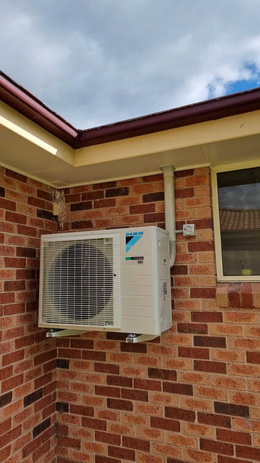 Outdoor Air Conditioning Unit Mounted on A Brick Wall — Canobolas Air in Mudgee, NSW