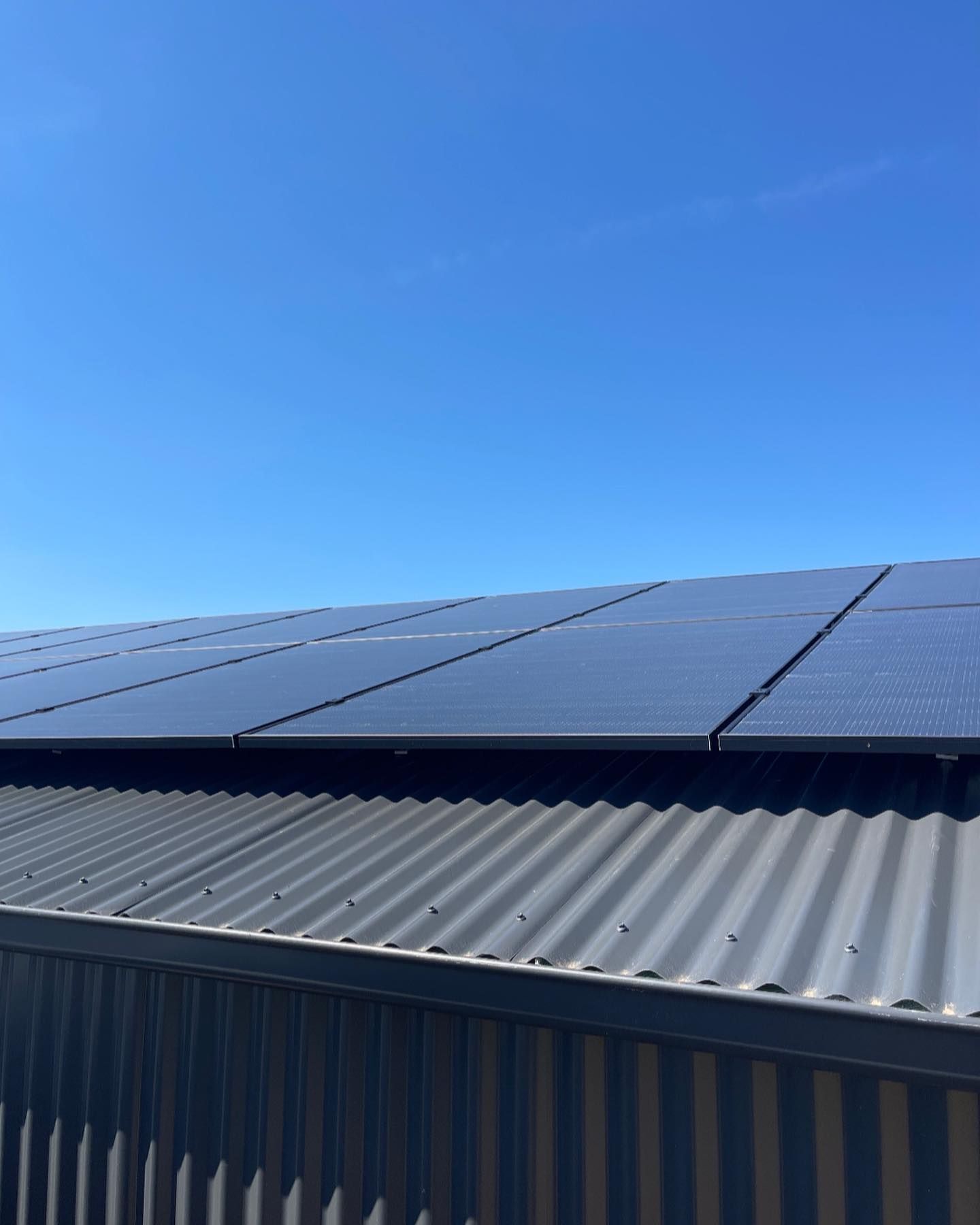 Solar Panels on A Corrugated Metal Roof Against a Bright Blue Sky — Canobolas Air in Dubbo, NSW