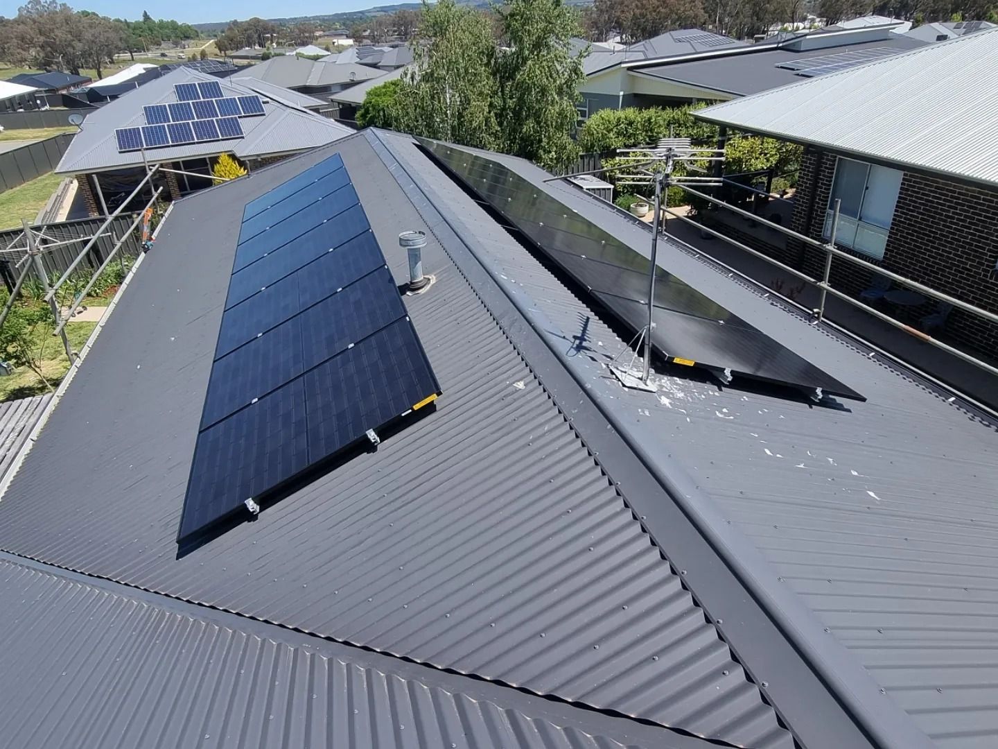 Solar Panels Installed on A Dark Gray Corrugated Metal Roof — Canobolas Air in Bathurst, NSW