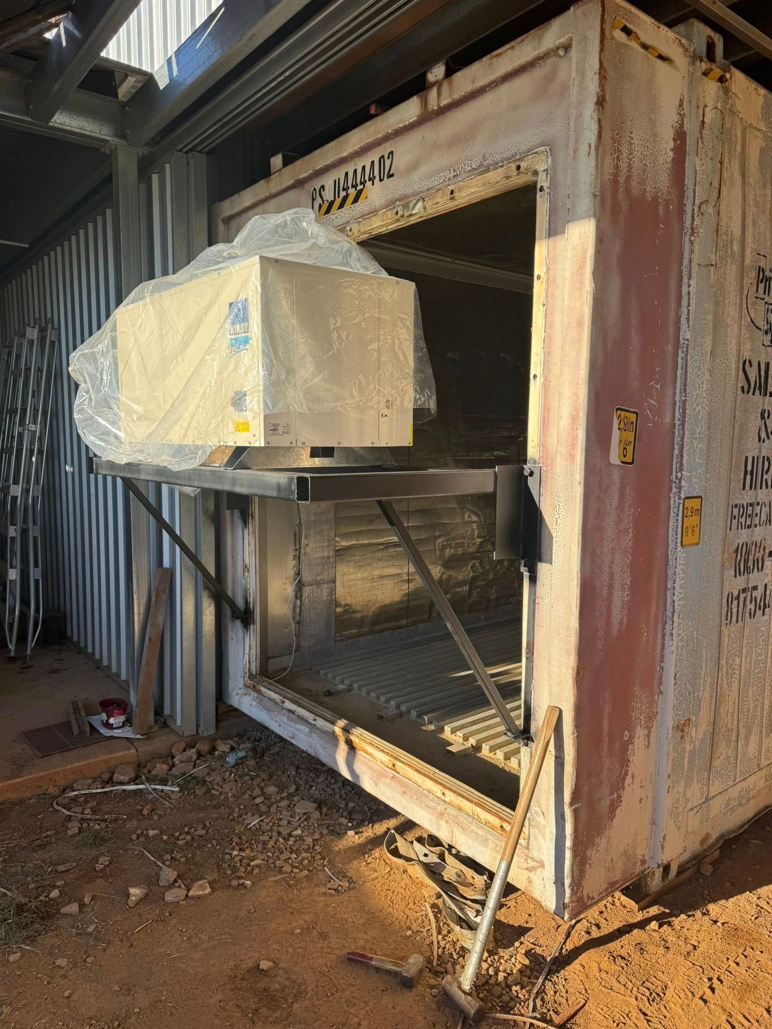 White Container with A Suspended Machine in An Opening — Canobolas Air in Orange, NSW
