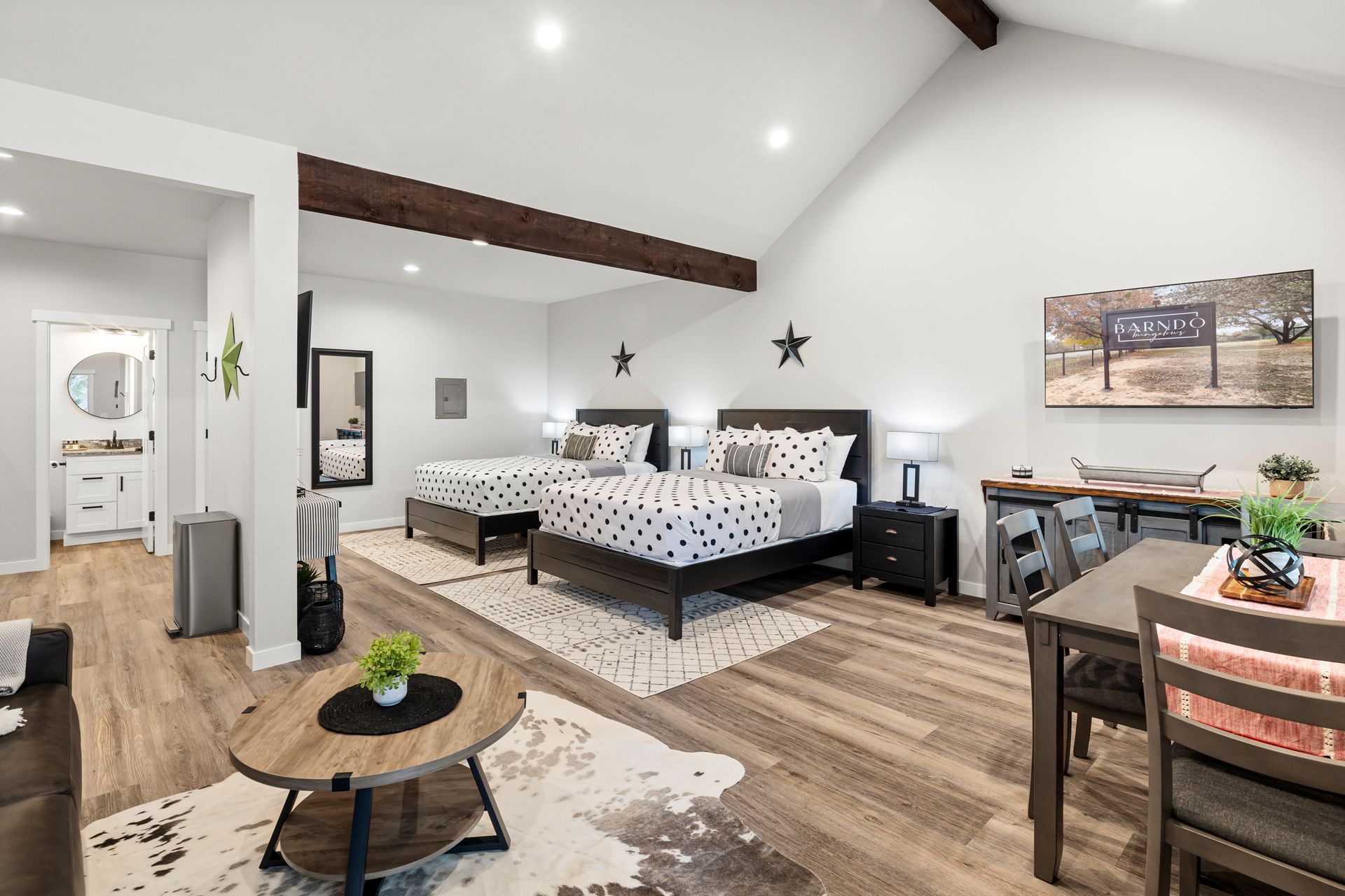 A bedroom with two beds , a table , chairs and a coffee table.