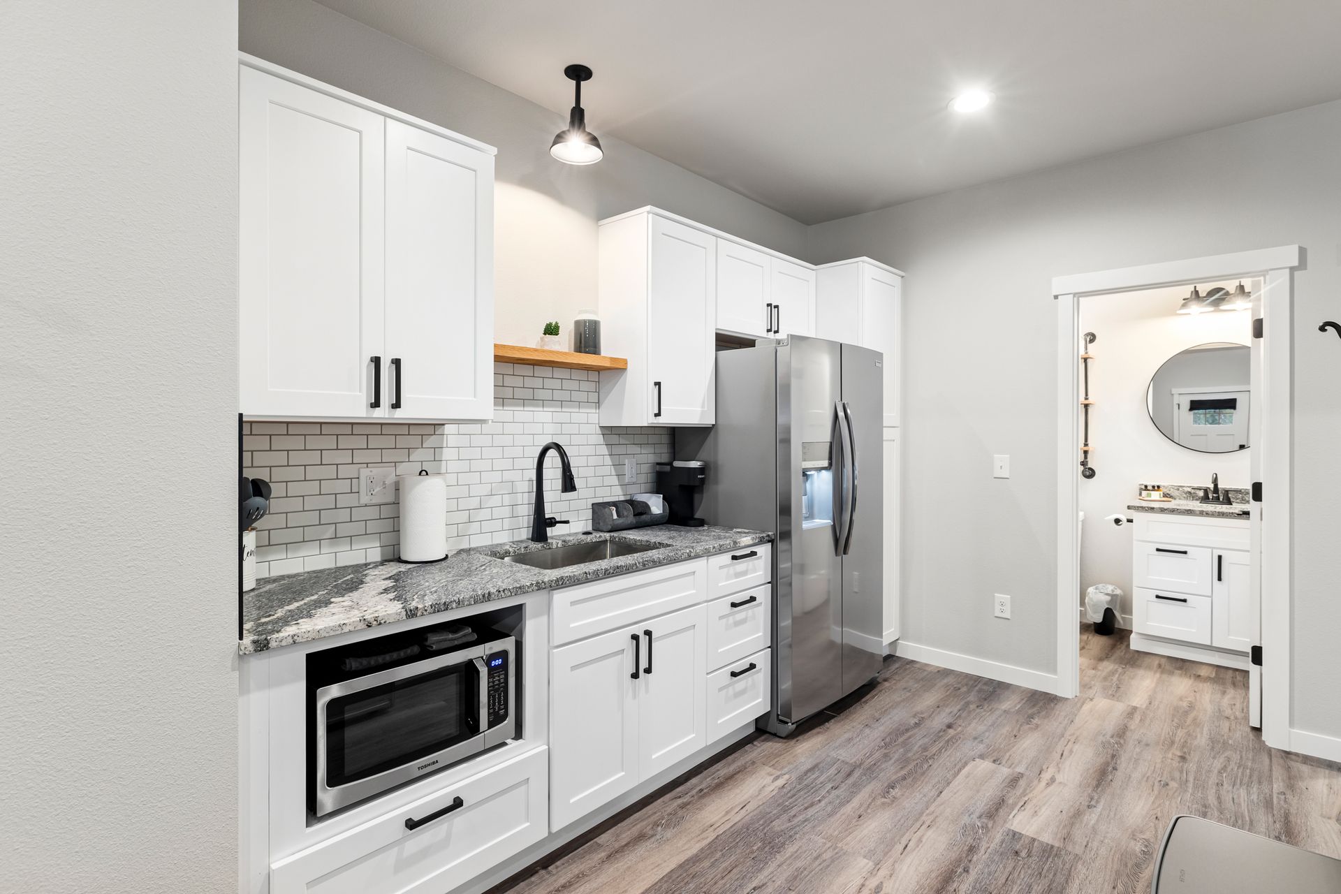 Kitchenette with full fridge w/ water/ice, air fryer micro and shaker cabinetry.