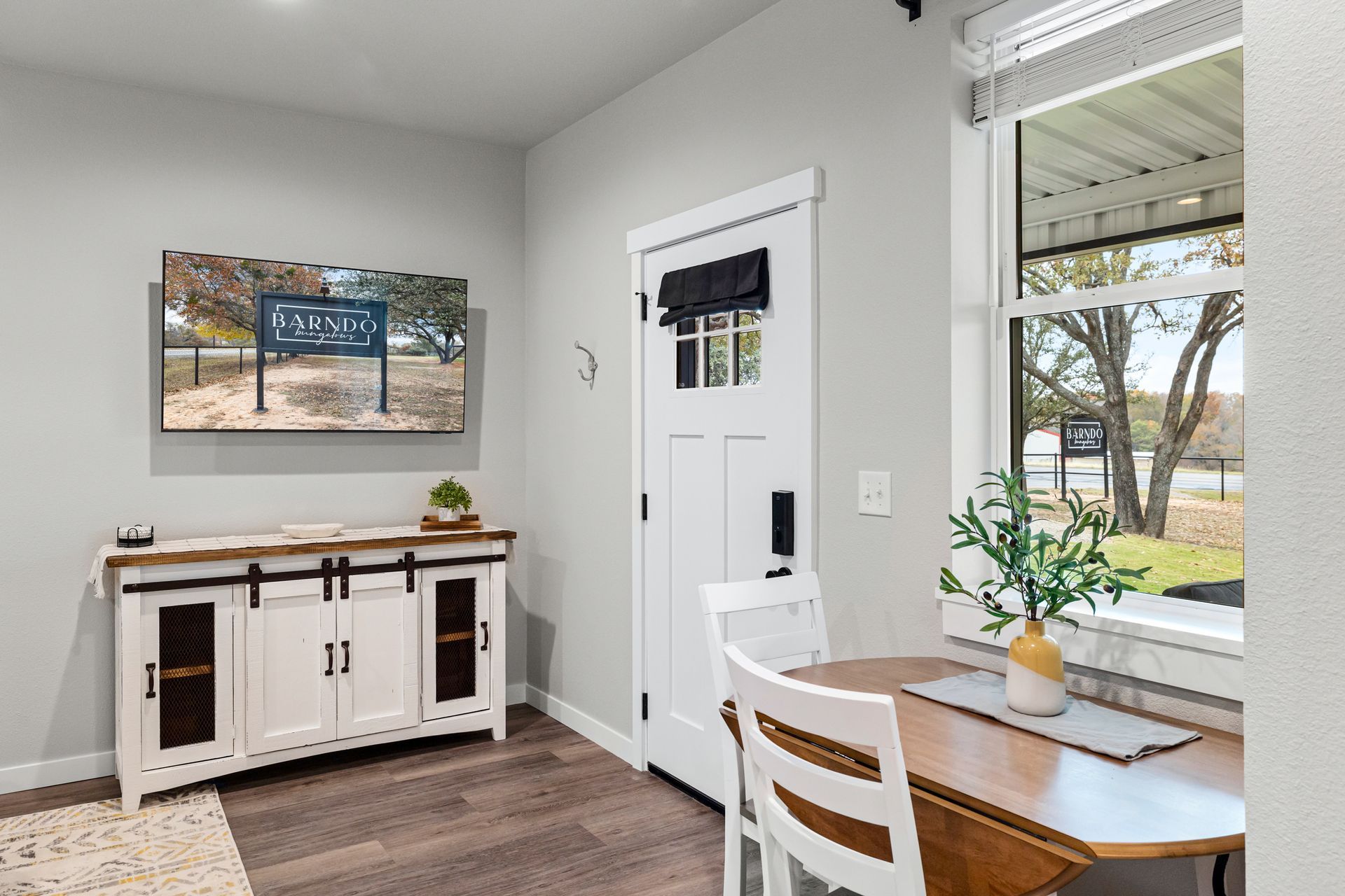 A dining room with a table and chairs and a sliding barn door.