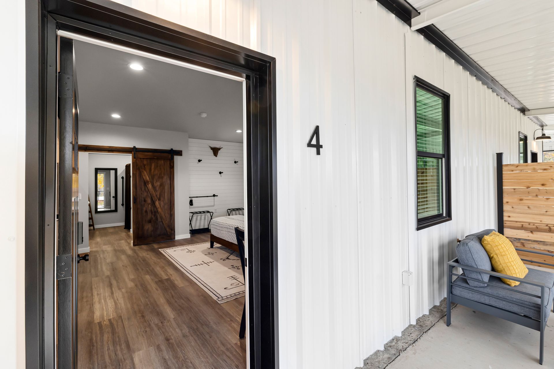 A doorway leading to a bedroom with a bed and a chair.
