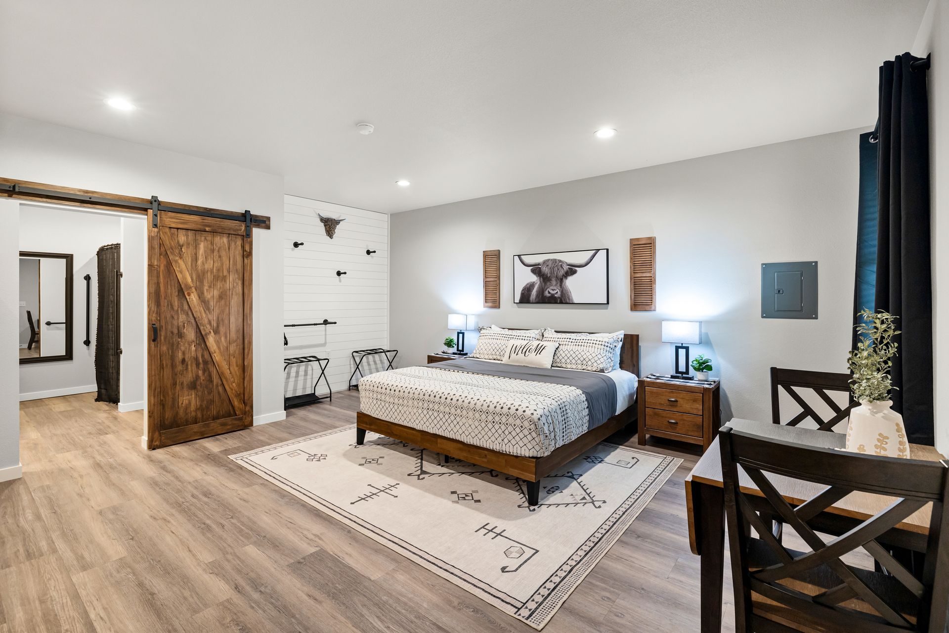 A bedroom with a king size bed and a sliding barn door.