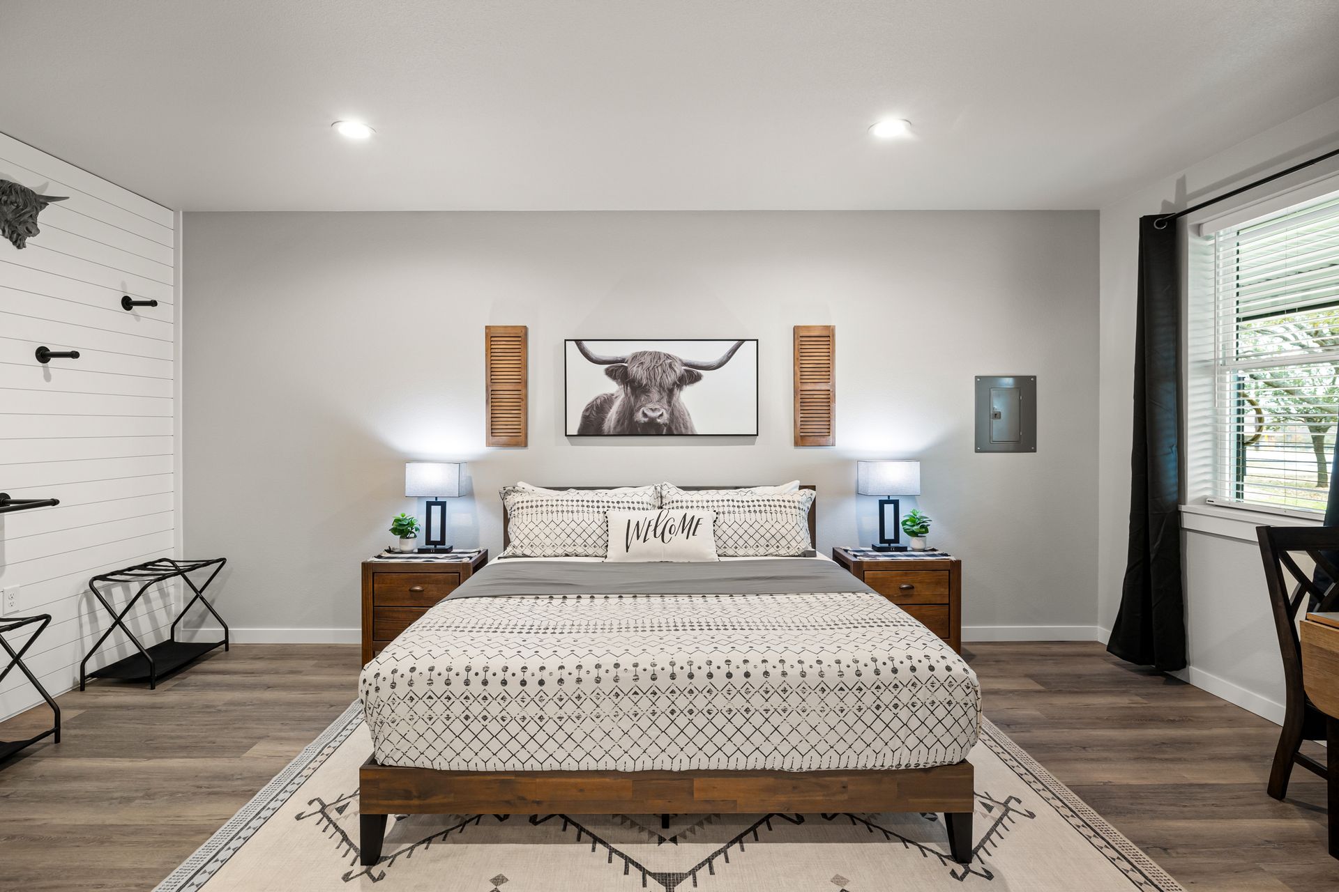 A bedroom with a large bed and a painting of a bull on the wall.