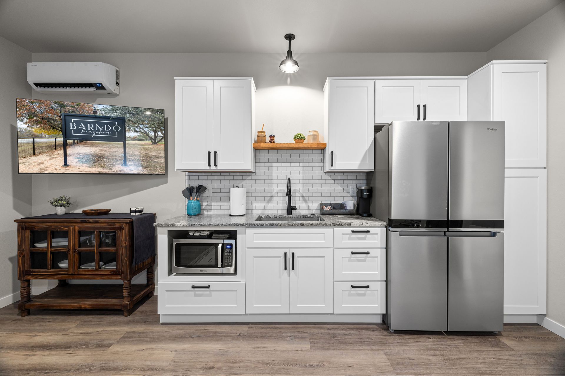 A kitchen with white cabinets and a stainless steel refrigerator.