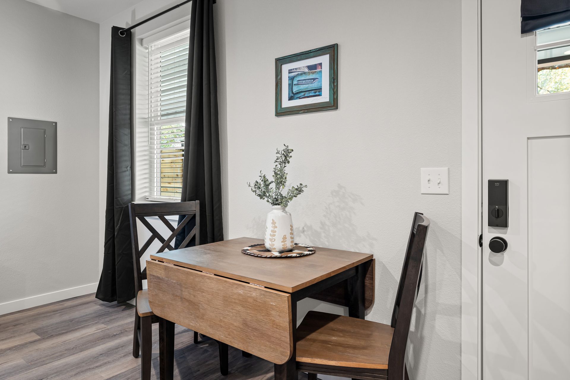 A dining room with a table and chairs and a window.