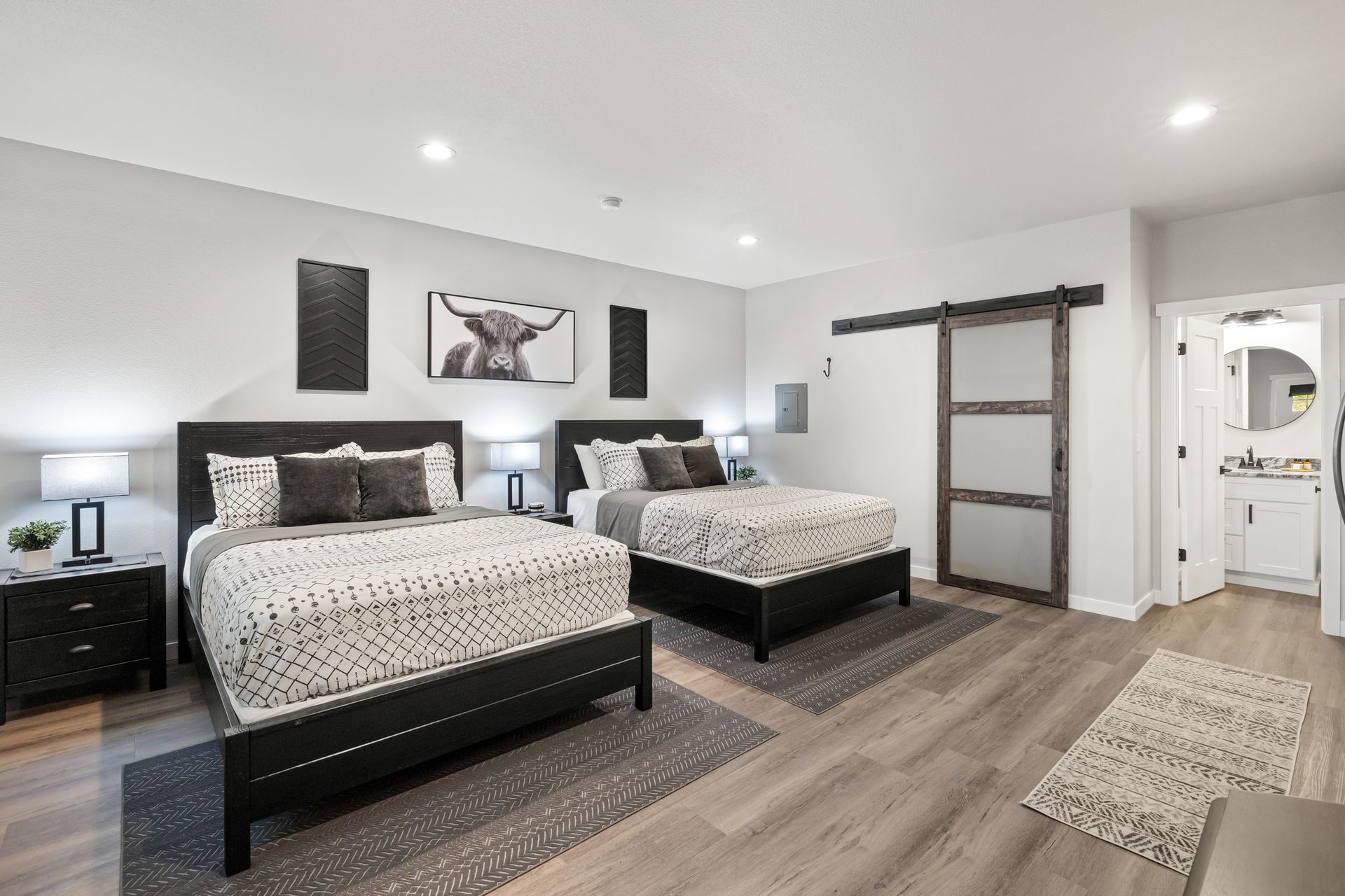 A bedroom with two beds and a sliding barn door.