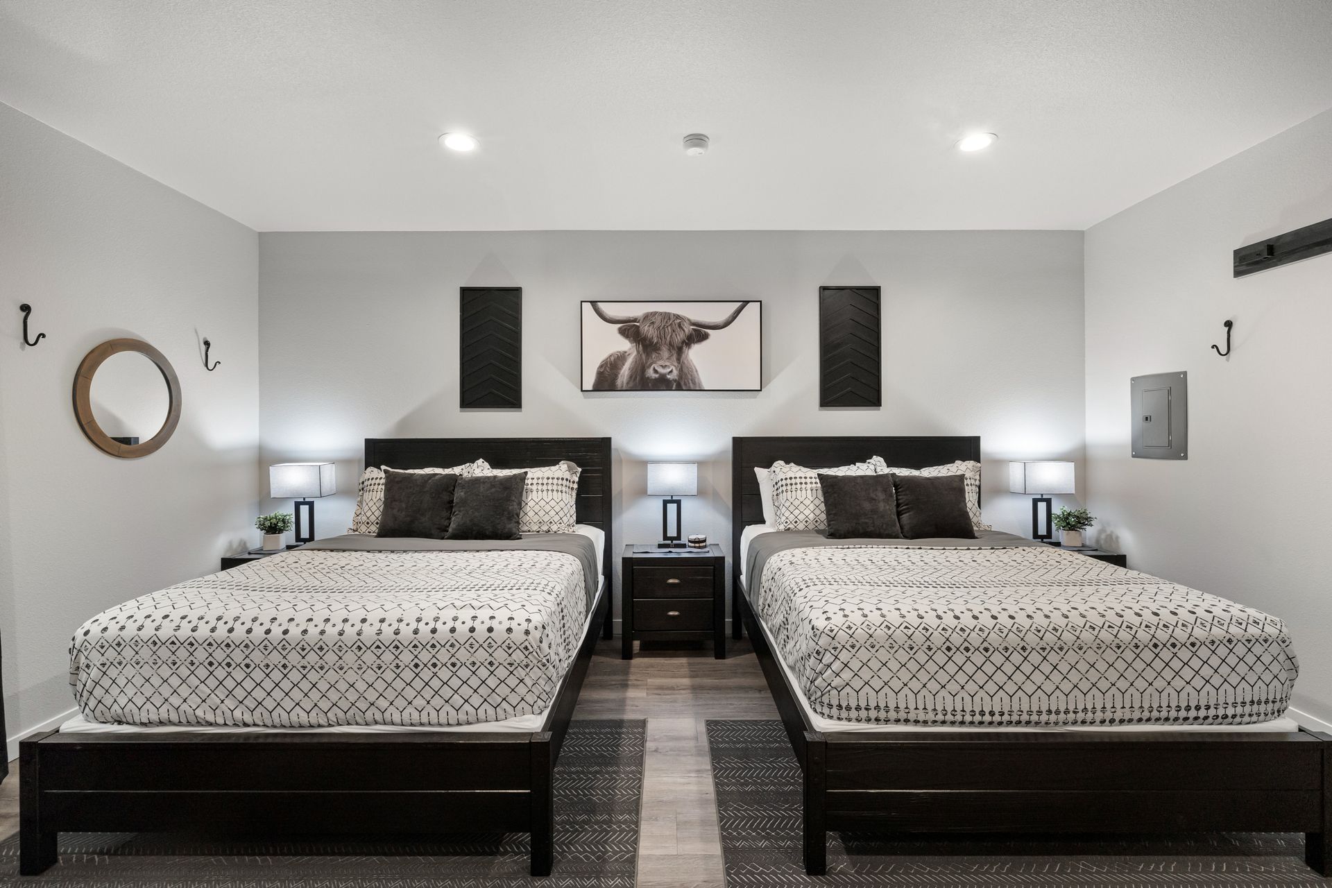 A bedroom with two beds and a picture of a bull on the wall.