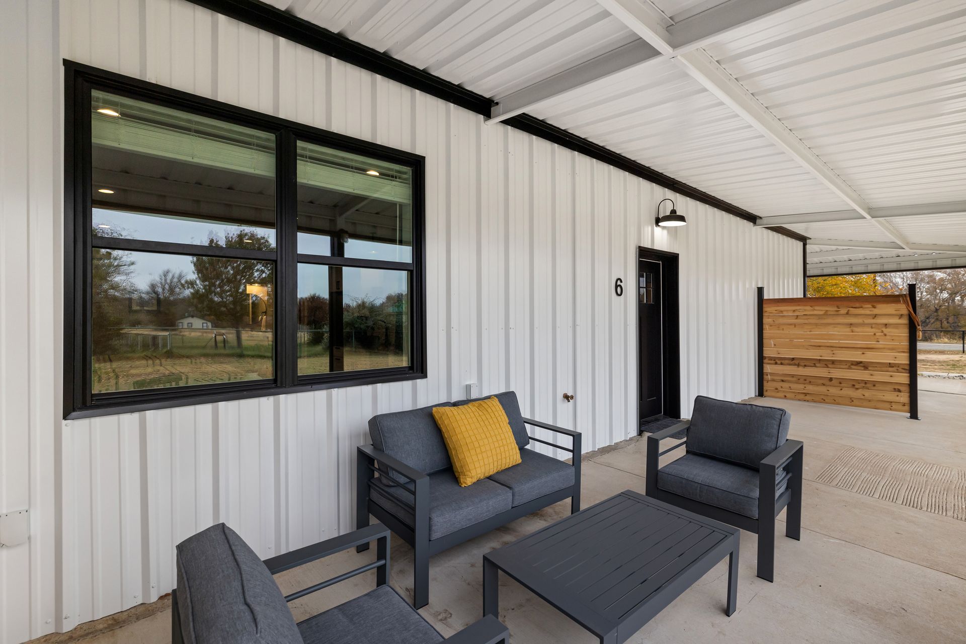 A patio with a couch , chairs , and a table.