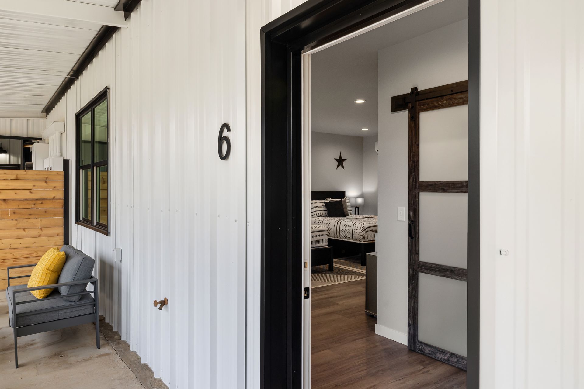 The door is open to a bedroom with a sliding barn door.