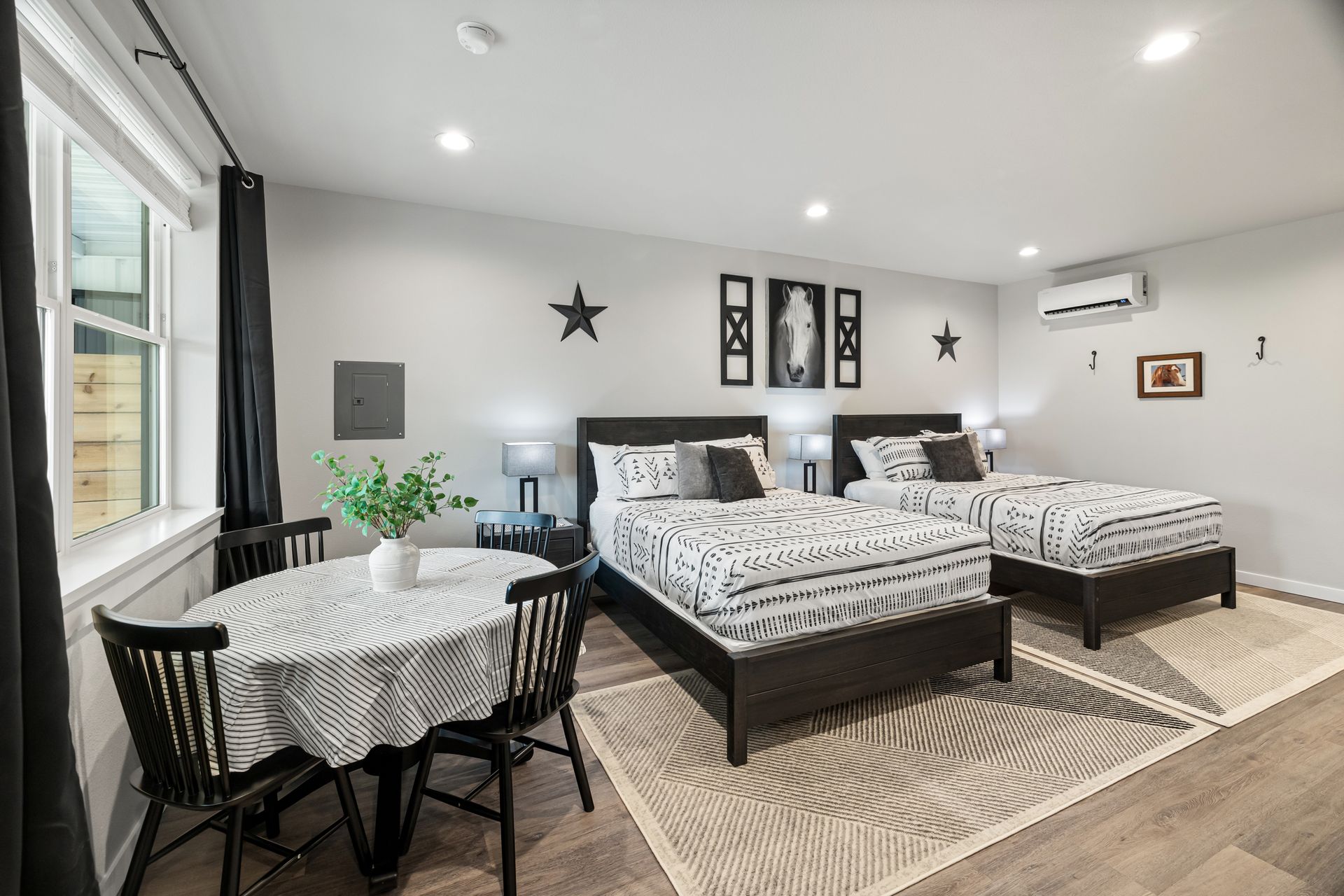 A bedroom with two beds , a table and chairs.