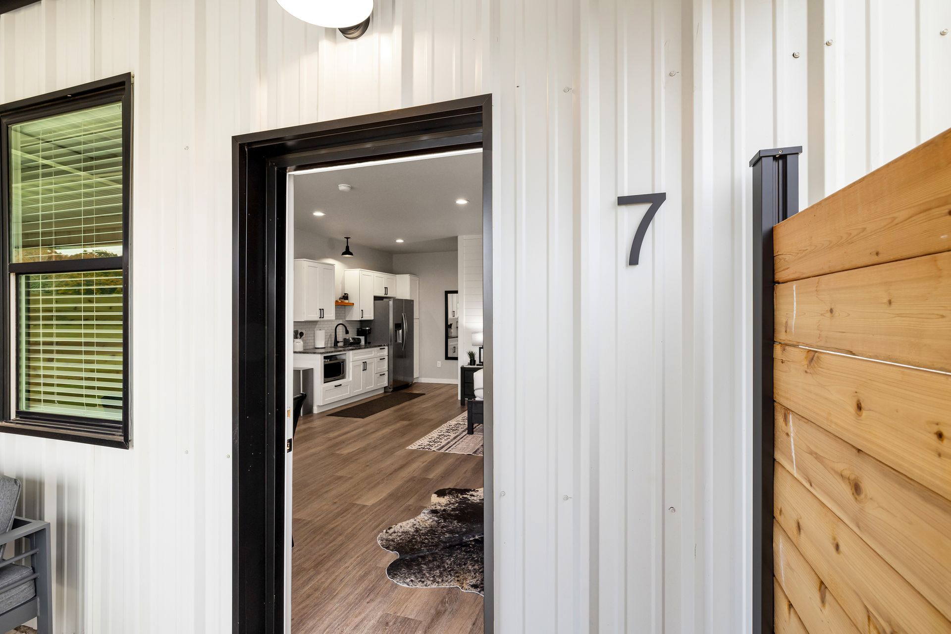 A white house with a wooden fence and a door with the number 7 on it.