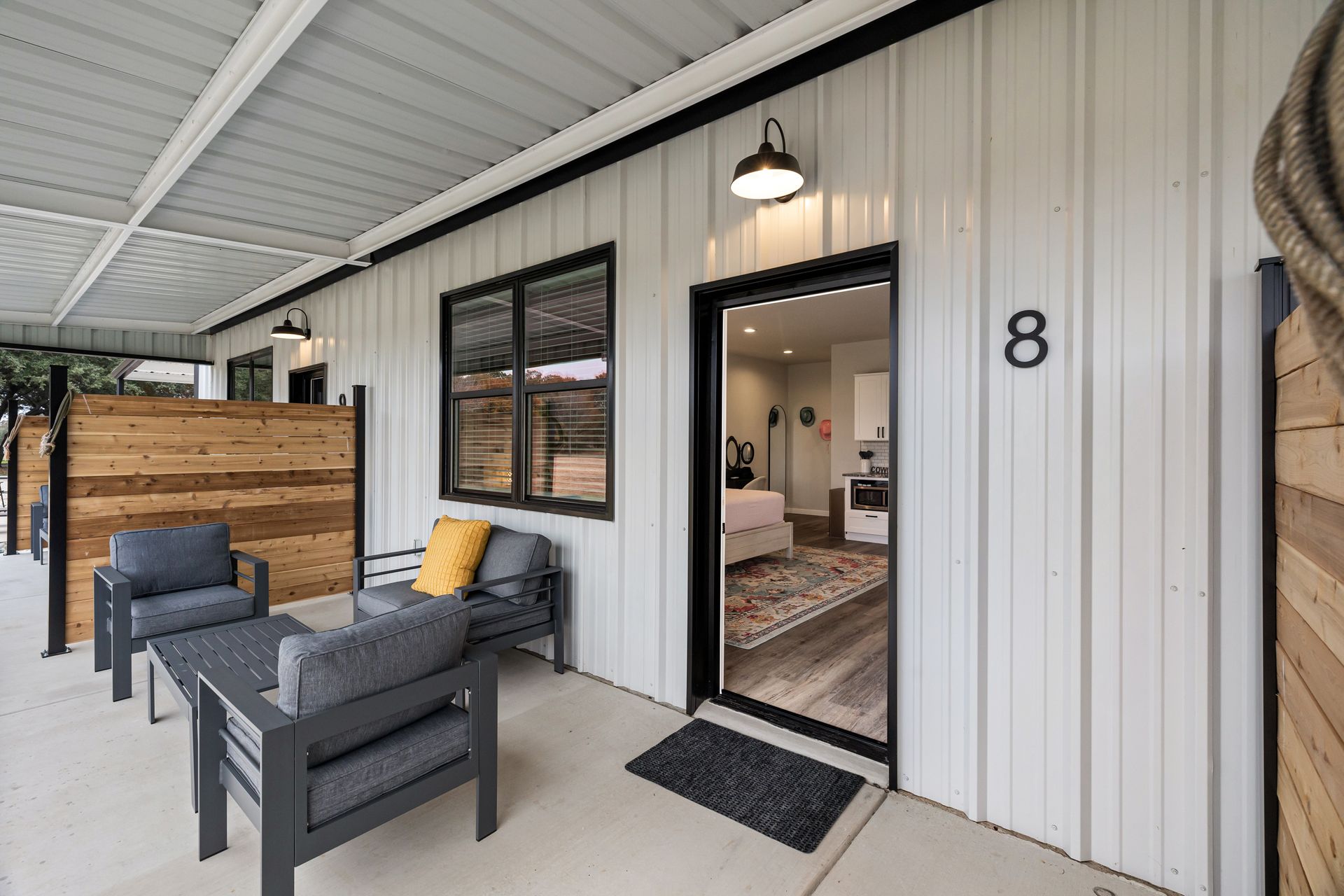 A patio with chairs and a table in front of a house with the number 8 on it.