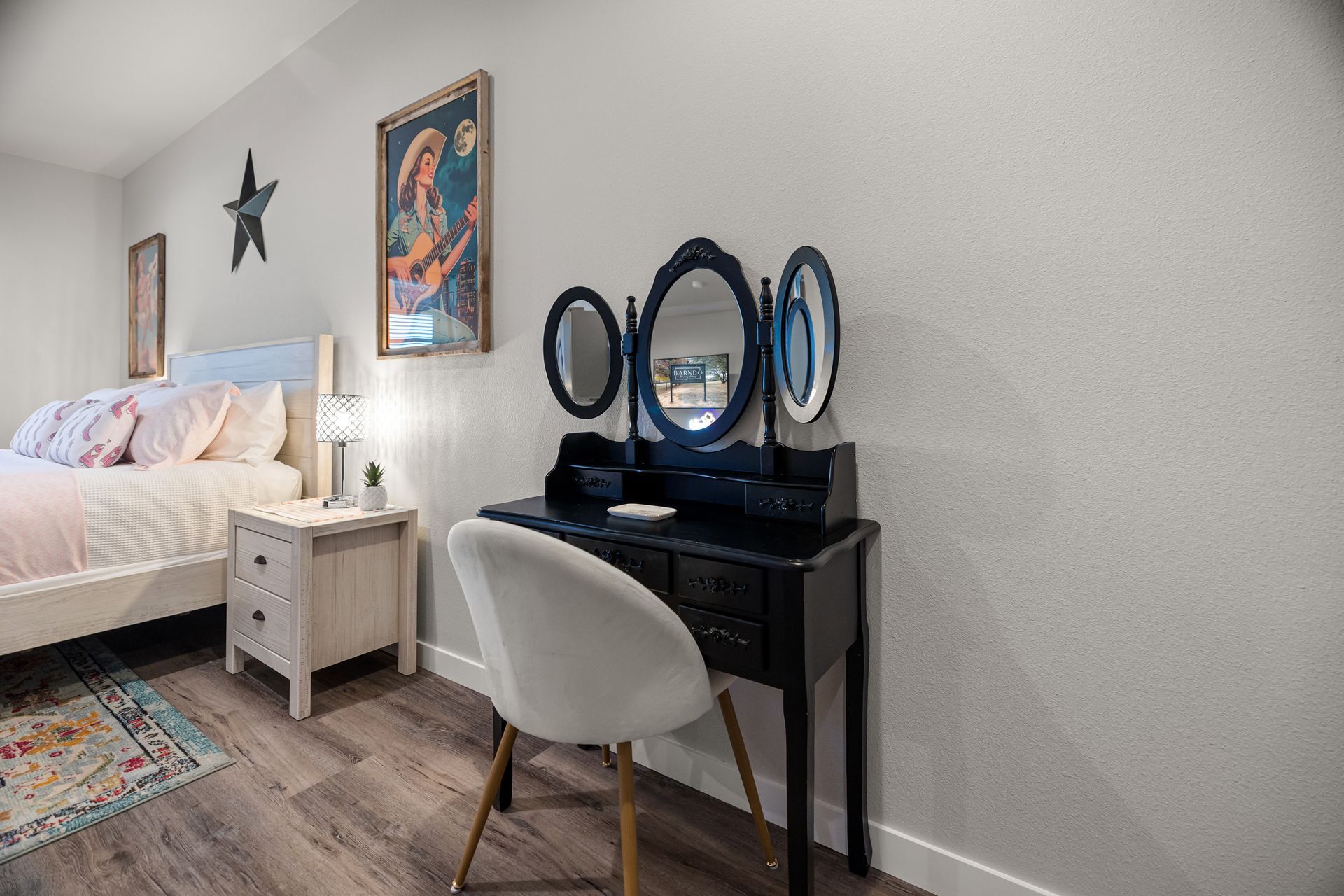 A bedroom with a bed , nightstand , desk and chair.