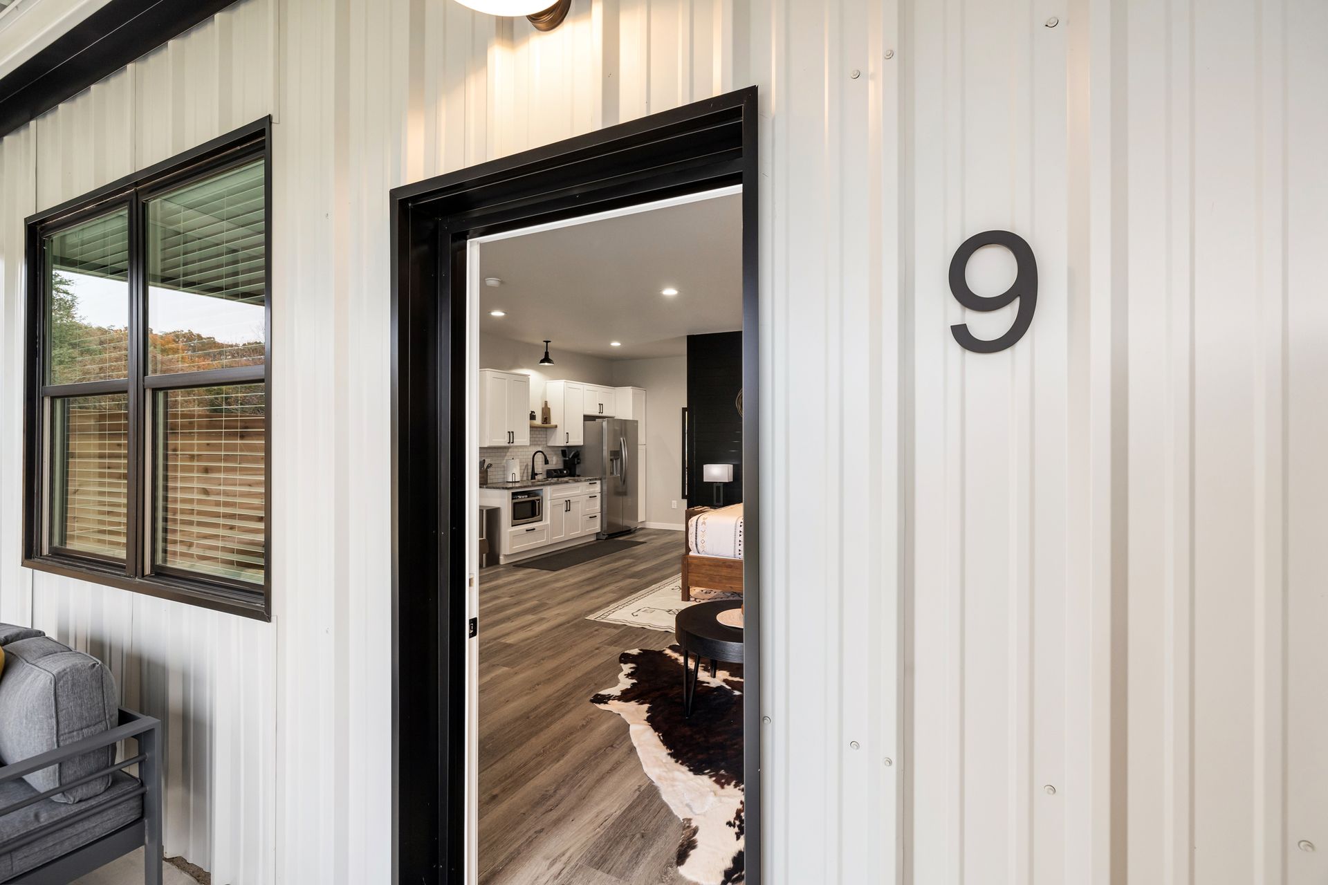 A white building with a black door and the number 9 on it.