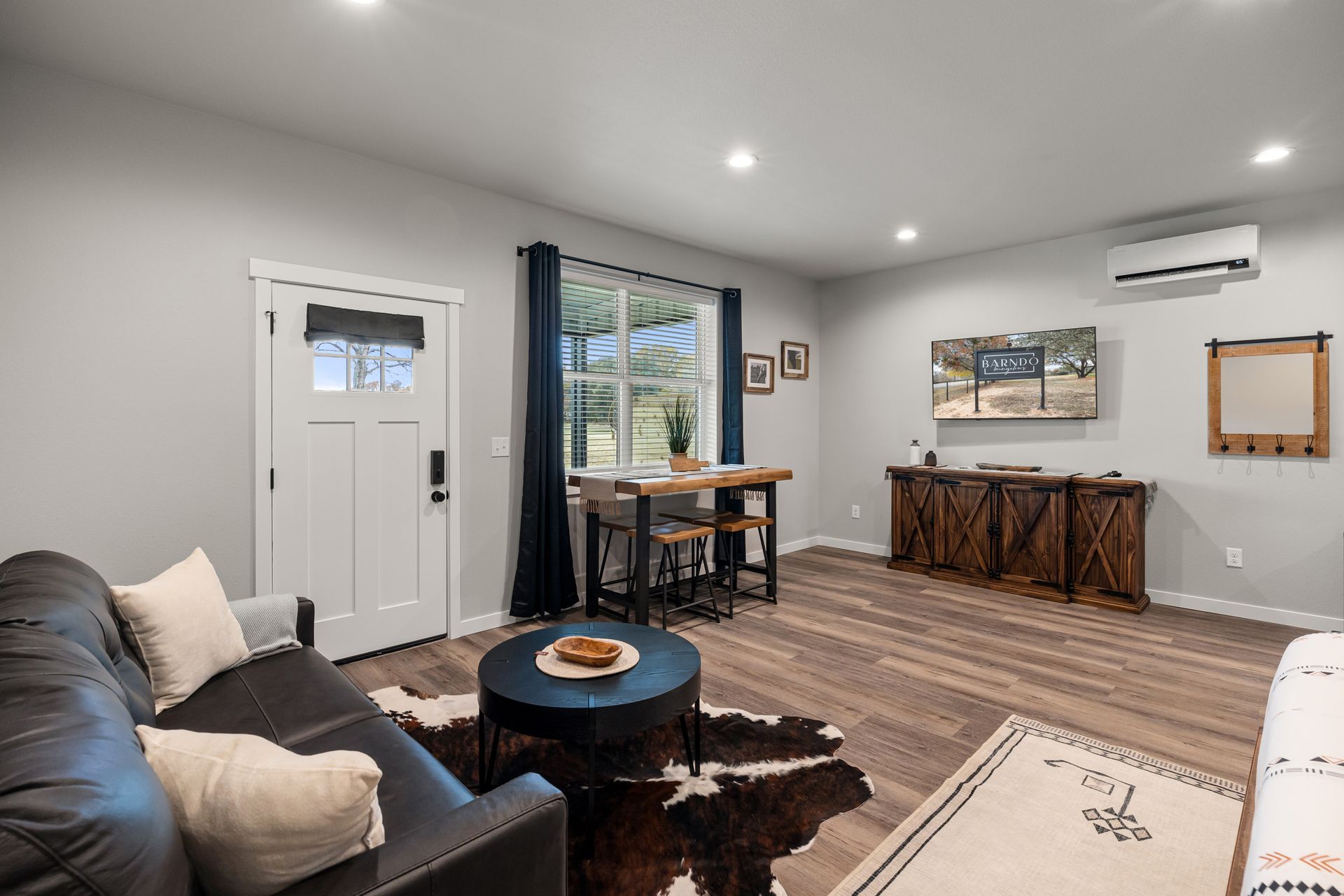A living room with a couch , table , chairs and a rug.