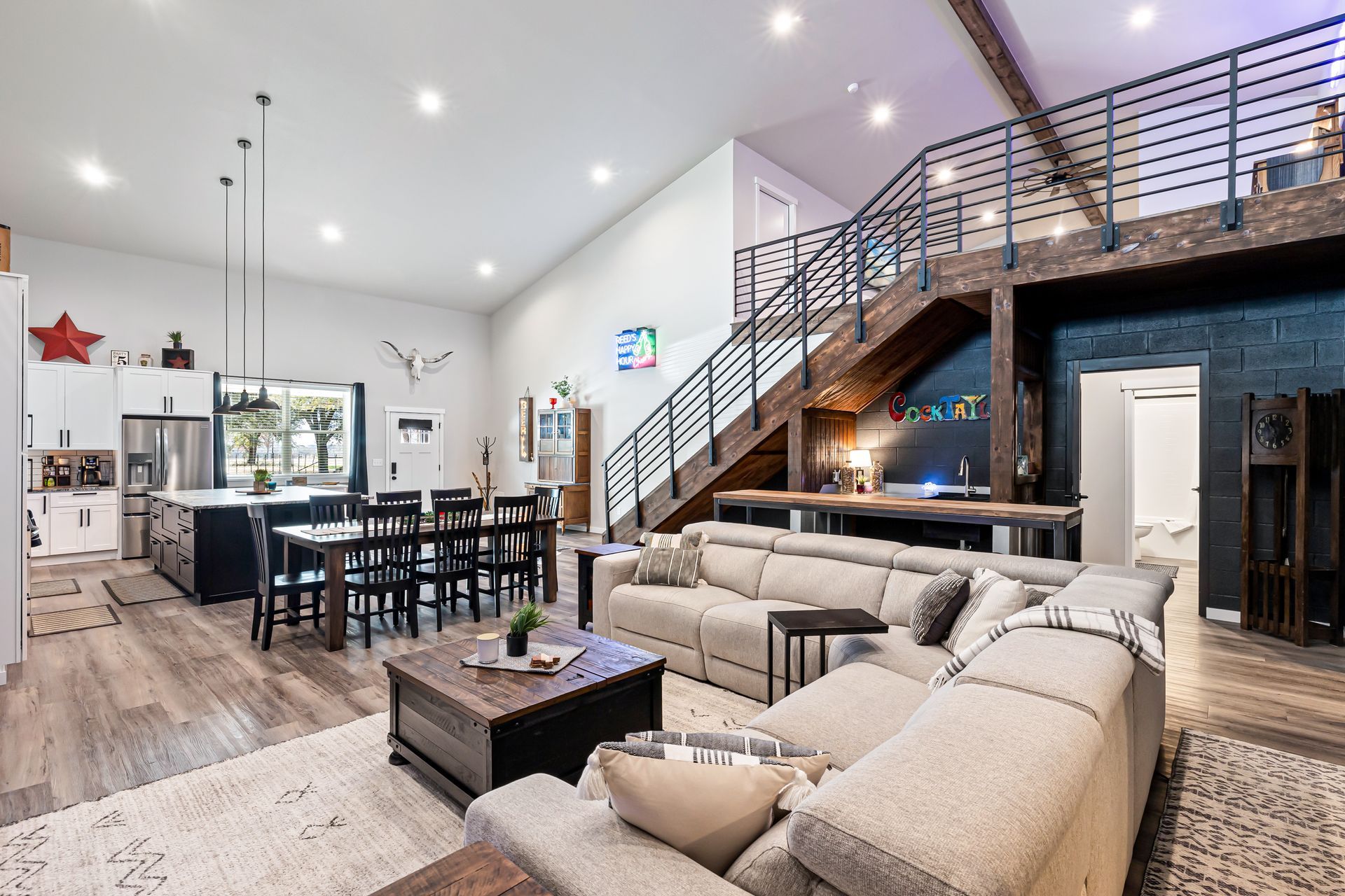 A living room filled with furniture and a staircase leading to the second floor.
