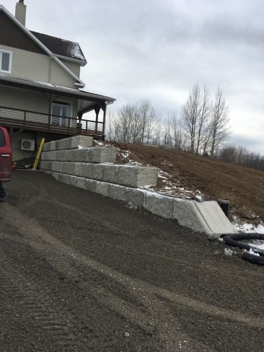 Une camionnette rouge est garée devant une grande maison