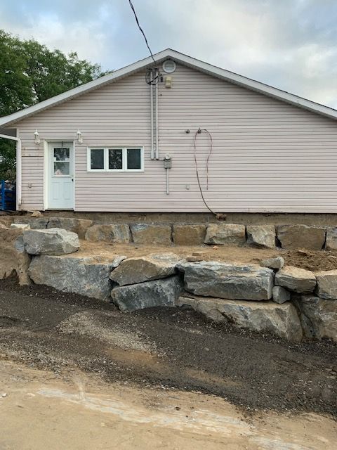 Une maison avec un mur de pierre devant.