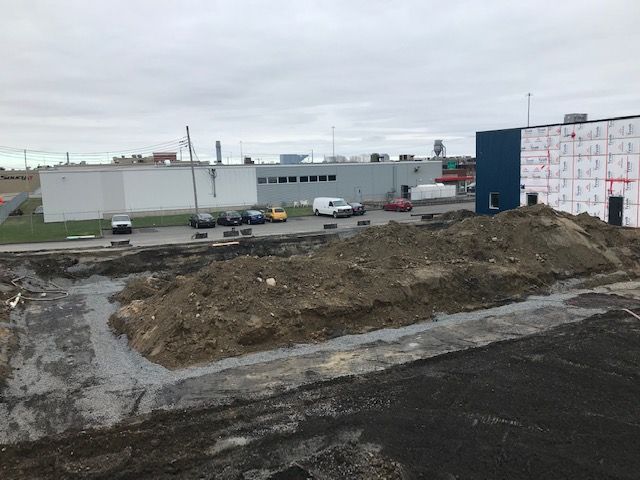 Un gros tas de terre se trouve devant un bâtiment en construction.