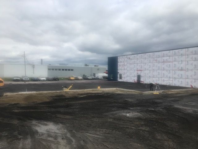 Un grand bâtiment avec beaucoup de voitures garées devant.