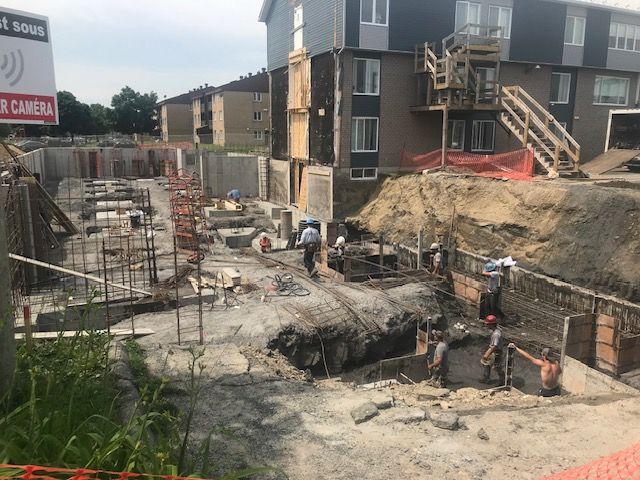 Un groupe d'ouvriers du bâtiment travaillent sur un bâtiment en construction.