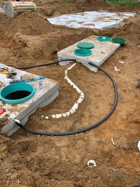 Une fosse septique est en cours de construction dans la terre.