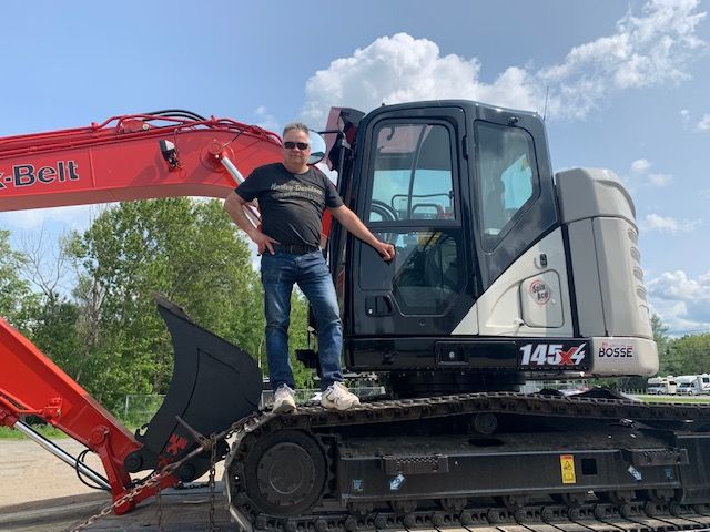 Un homme se tient à l'arrière d'un bulldozer.