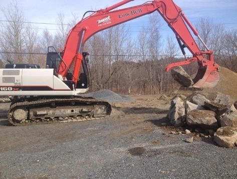 Une pelle rouge et blanche avec un seau sur lequel est écrit Komatsu