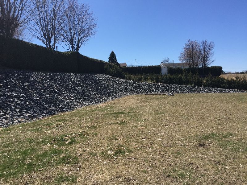 Un gros tas de pierres se trouve au milieu d'un champ herbeux.