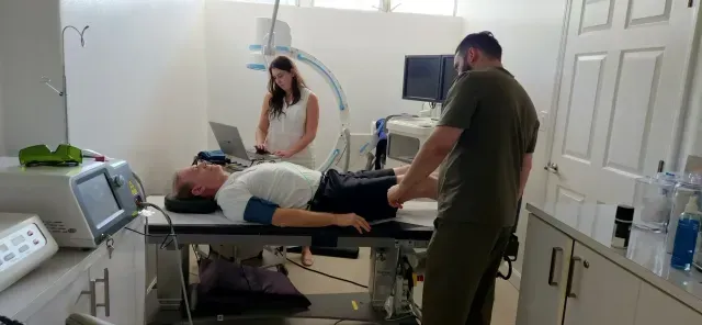 Woman giving leg massage to another woman lying on a massage table.