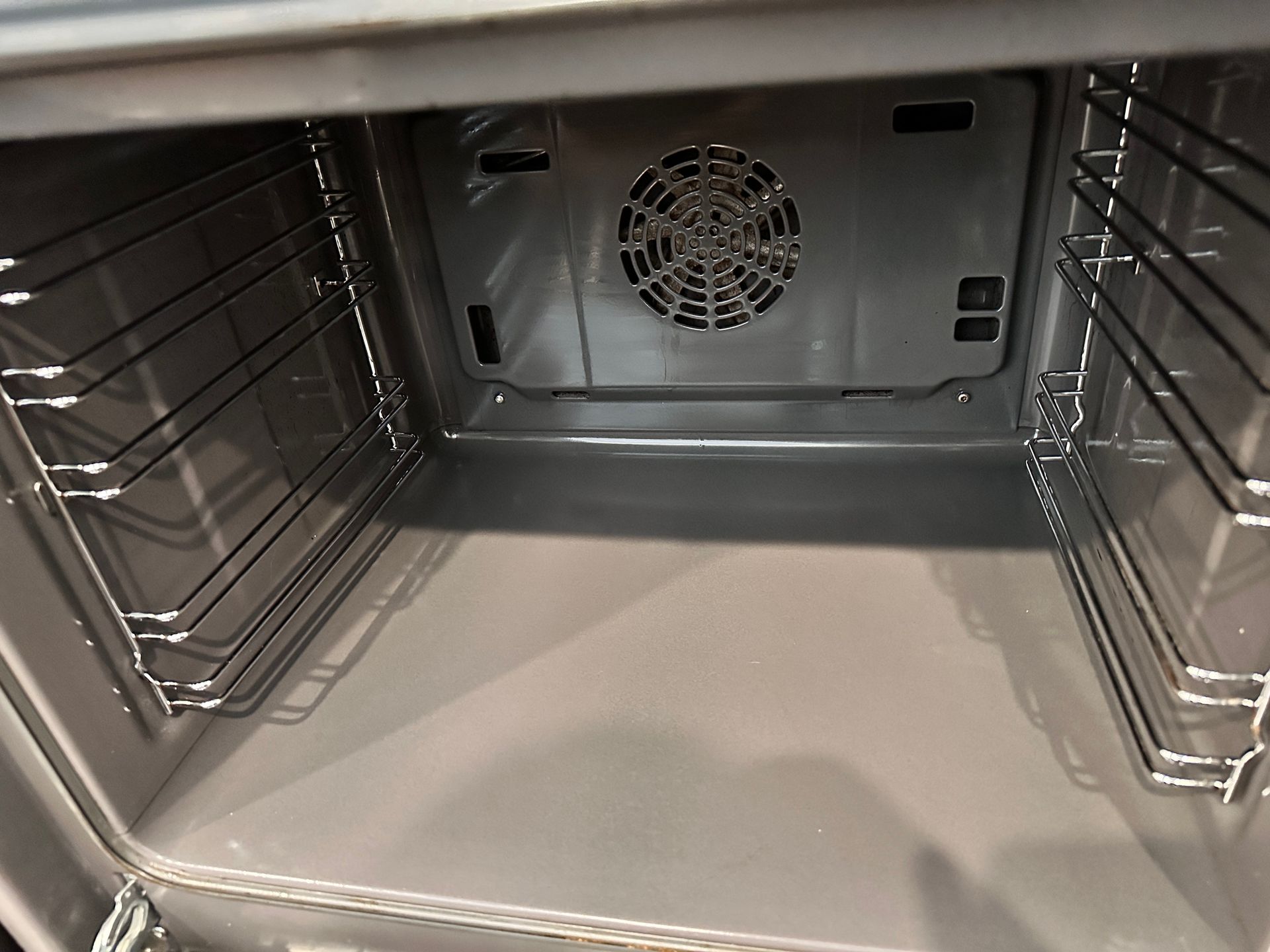A close up of the inside of an oven with a fan