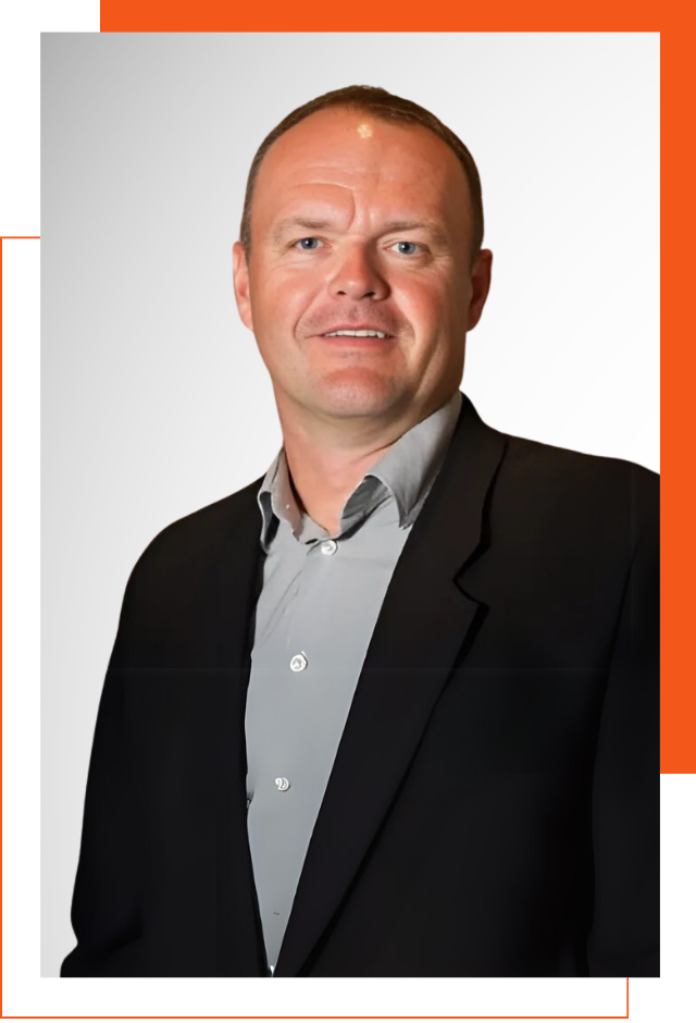 A man in a suit is smiling for the camera