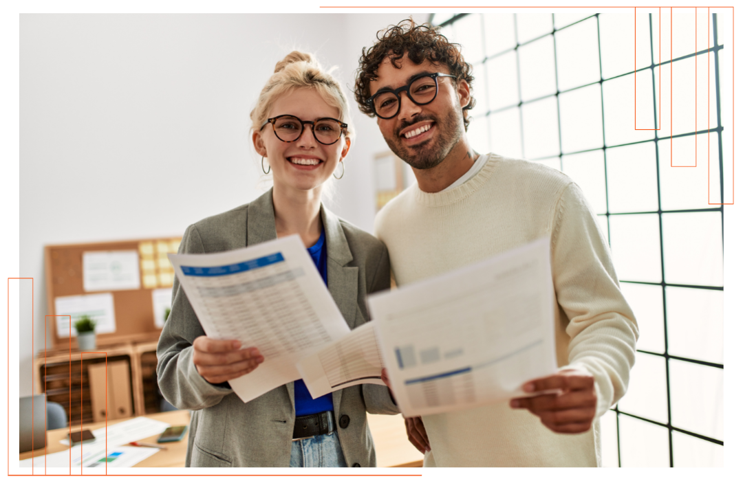 A man and a woman are standing next to each other holding papers.