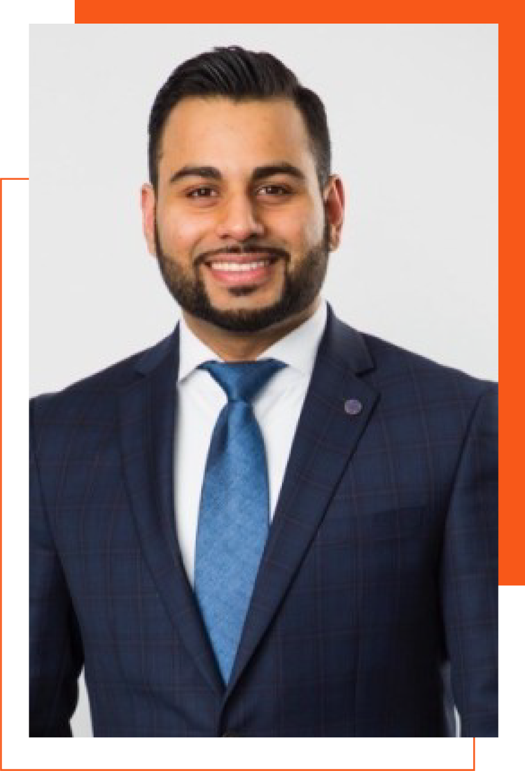 A man in a suit and tie is smiling for the camera