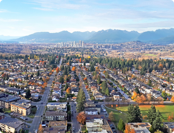 An aerial view of a residential area with mountains in the background.