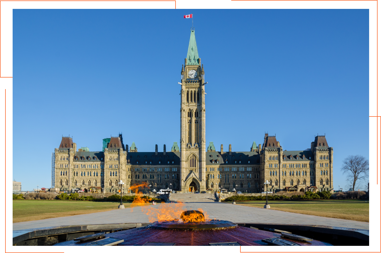 A large building with a clock tower and a fountain in front of it