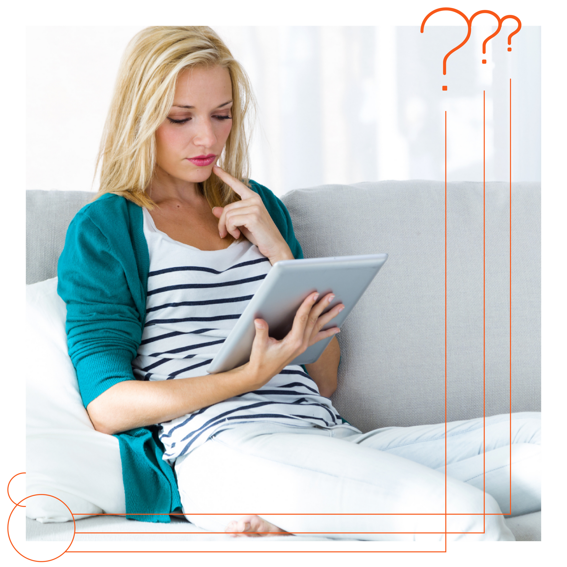 A woman is sitting on a couch using a tablet computer