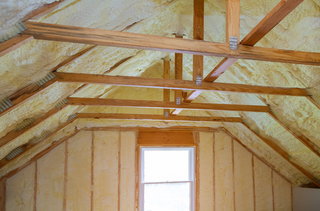 There is a window in the attic of a house.