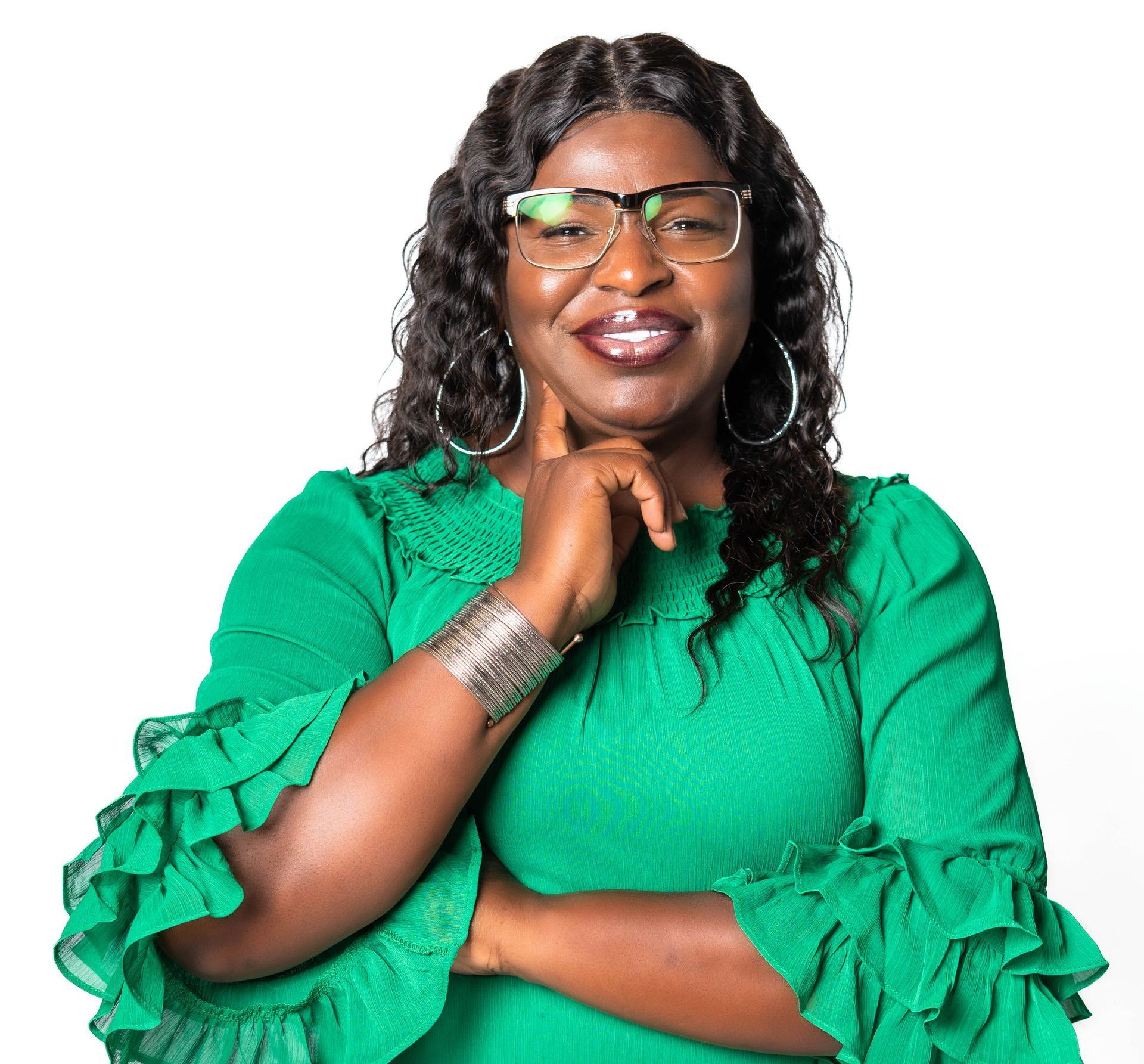 a woman wearing glasses and a green top with ruffled sleeves