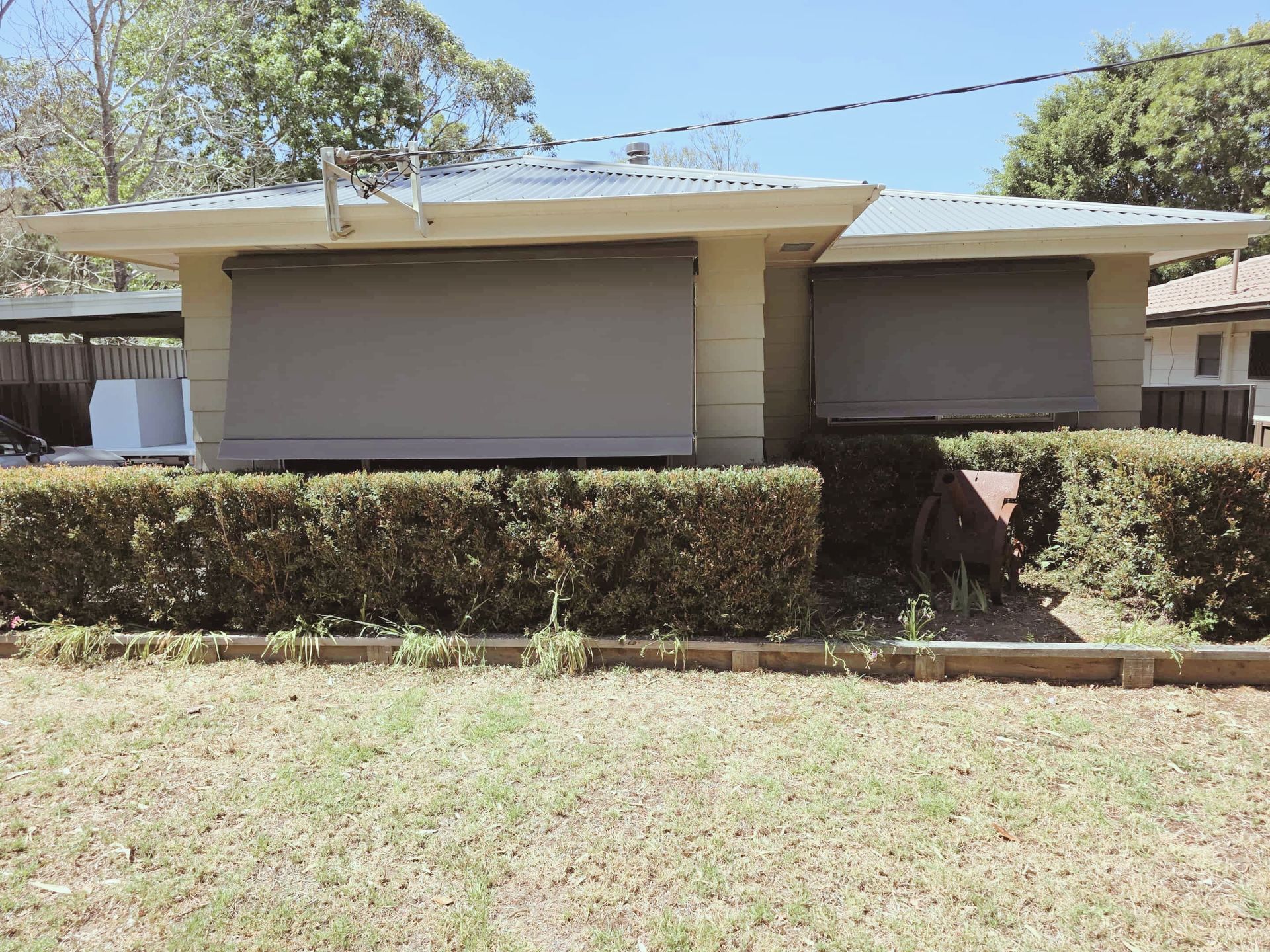 Beige and white striped awning extending from a building with teal siding.