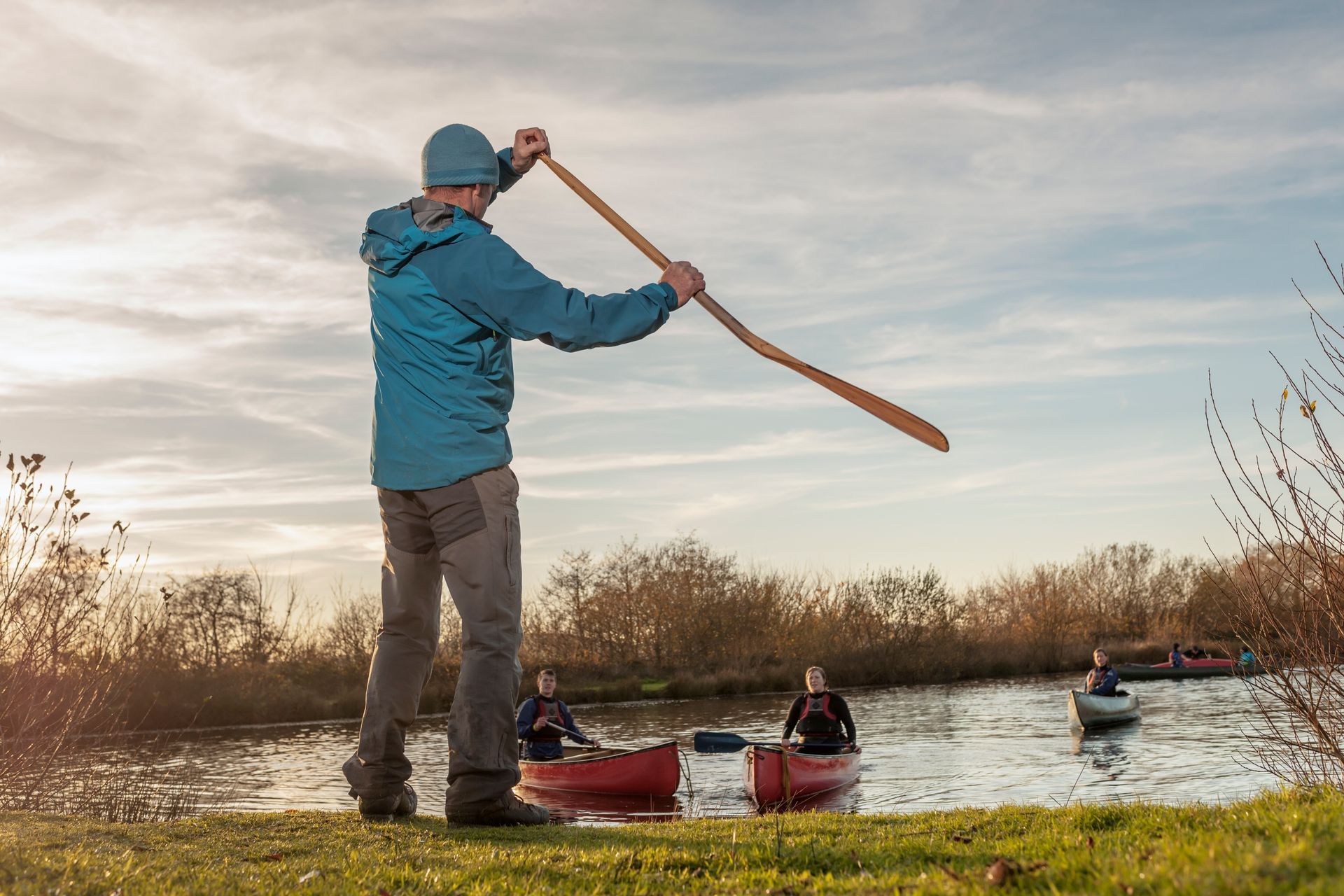 A man with an oar prepares to get into the water while paddling in Vermont