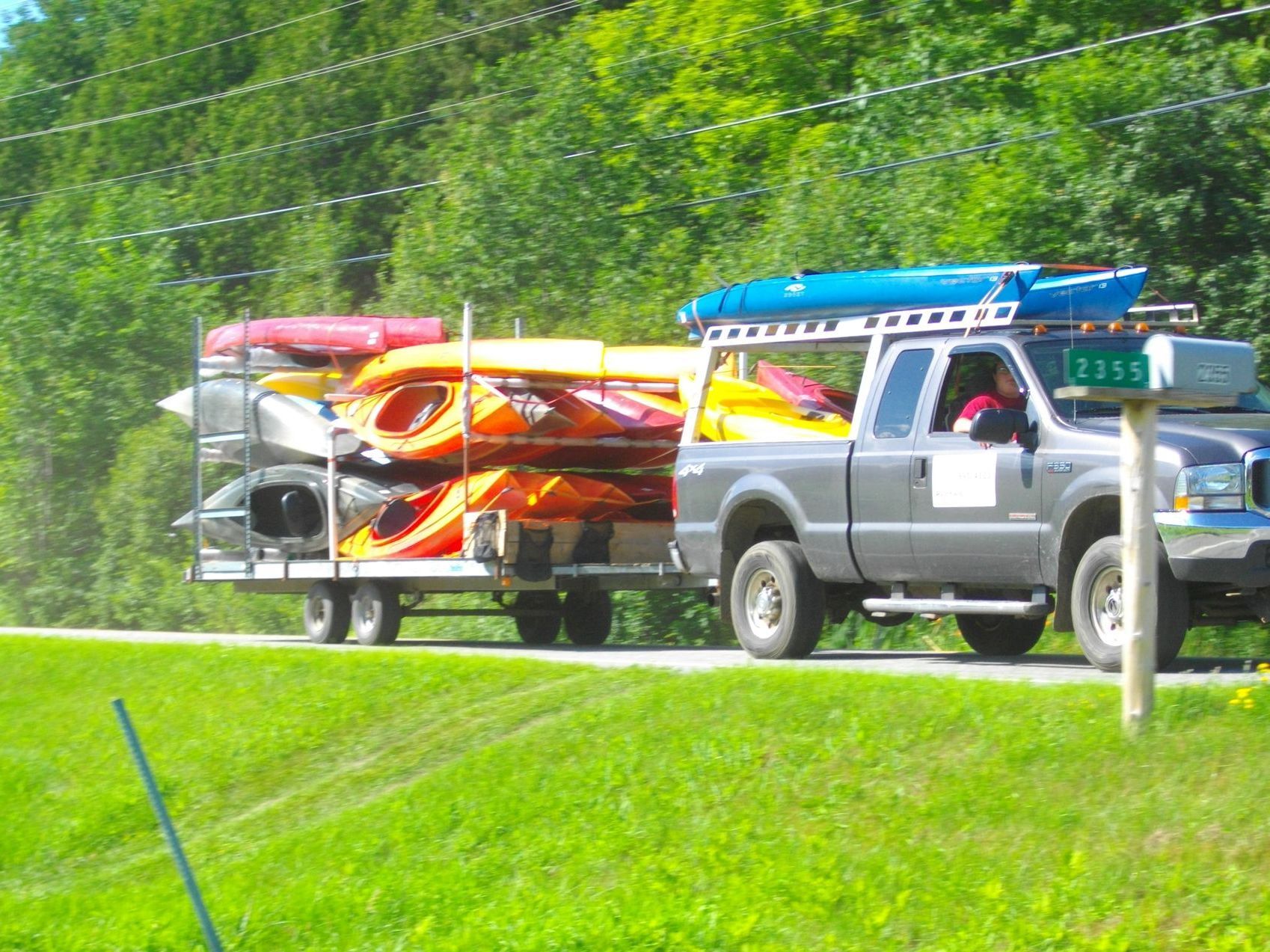 A truck is hauling kayaks on a trailer